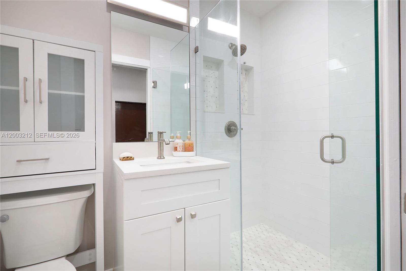 A modern bathroom features a white vanity, a glass-enclosed shower, and a toilet — 2368 SW 21st St Side, Miami FL 33145, MIAMI, FL