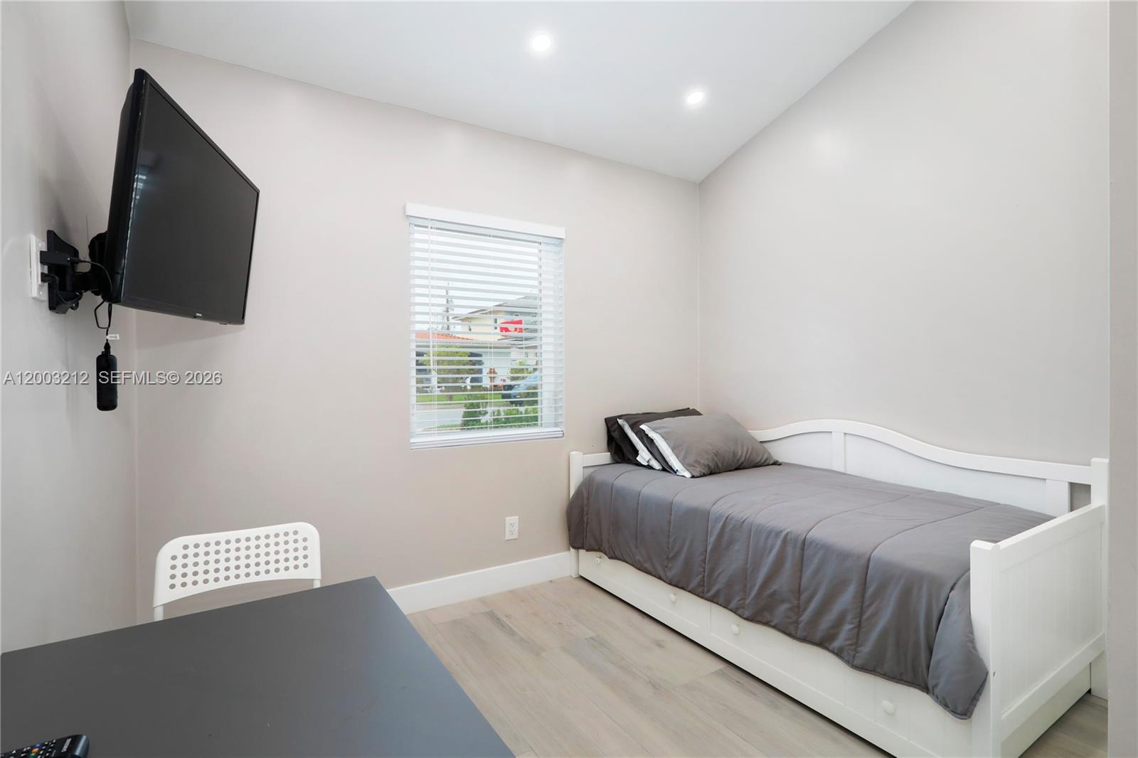 A bedroom features a white daybed, a wall-mounted television, and a desk with a chair — 2368 SW 21st St Side, Miami FL 33145, MIAMI, FL
