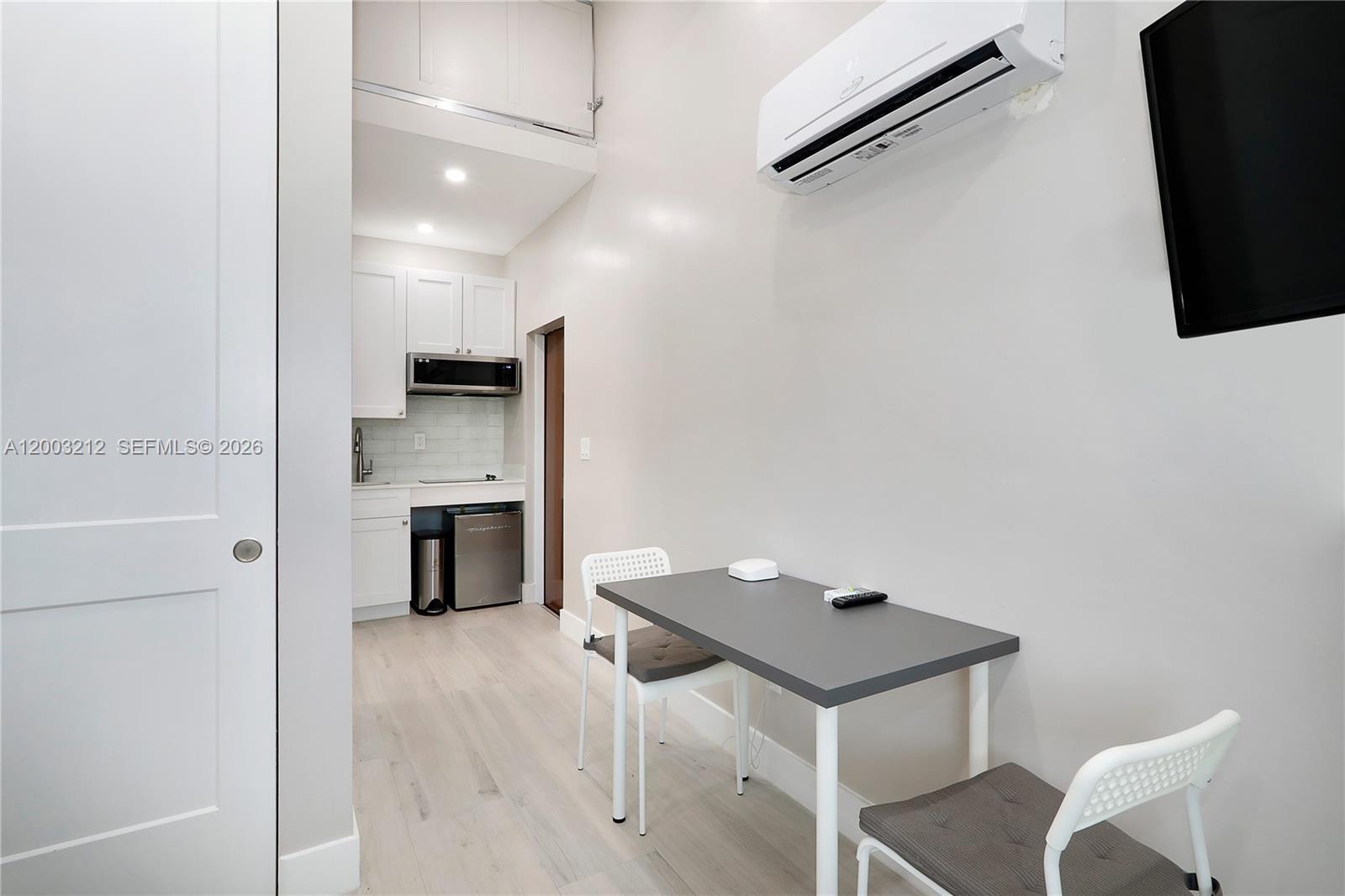 A small kitchen area with white cabinets and a dining table with two chairs — 2368 SW 21st St Side, Miami FL 33145, MIAMI, FL