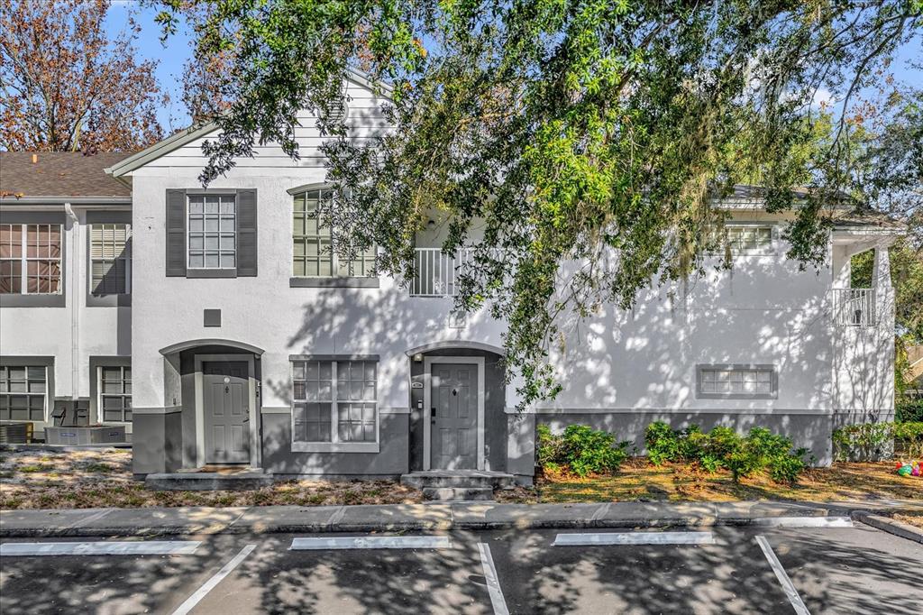 A two-story white townhouse exterior with gray trim, two front doors, and parking spaces — 4316 S KIRKMAN ROAD UNIT 1611, ORLANDO, FL