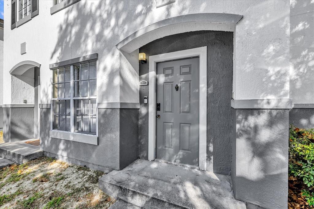 A gray front door with a knocker and keypad sits under an arched entryway — 4316 S KIRKMAN ROAD UNIT 1611, ORLANDO, FL