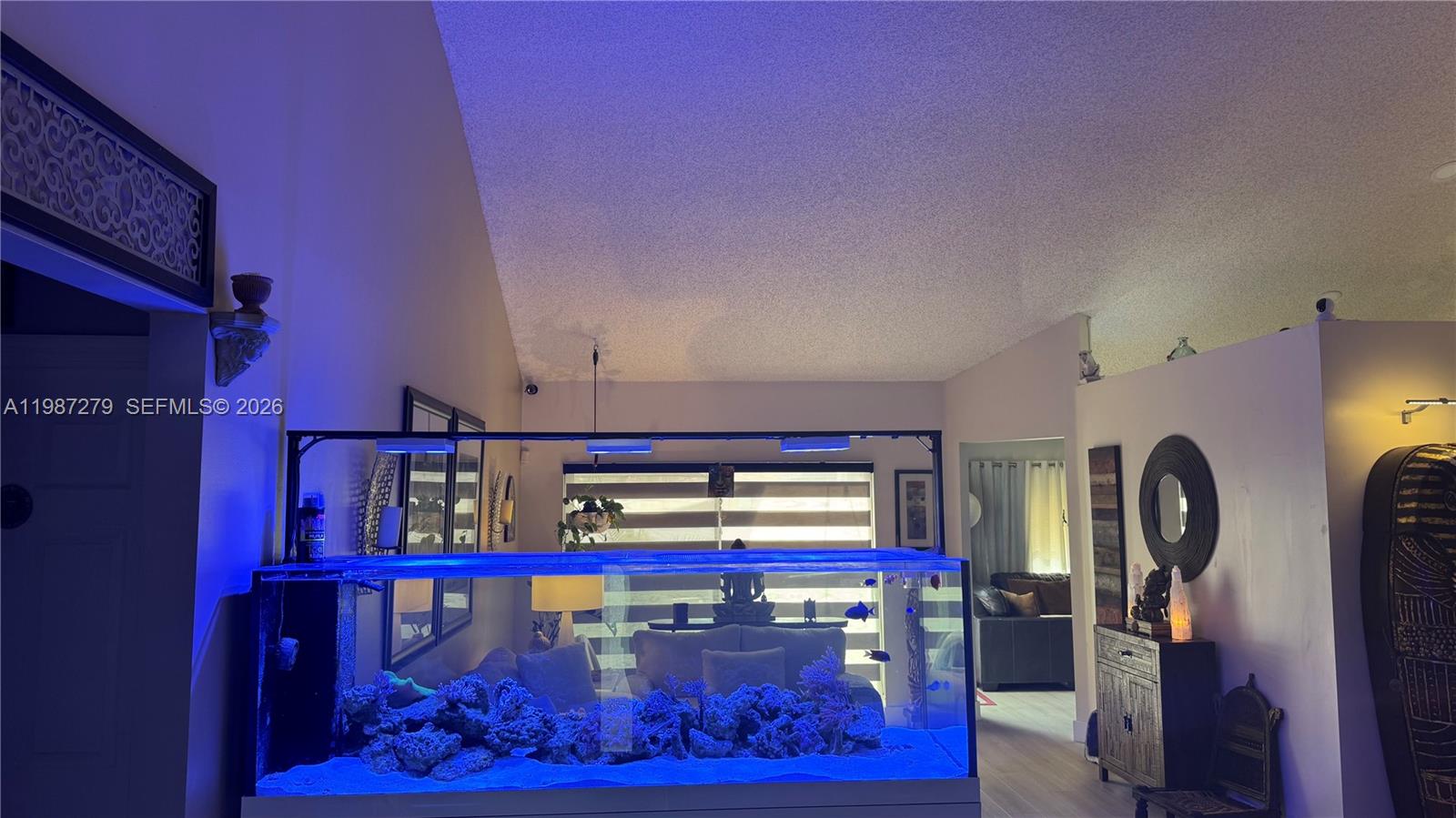 A large saltwater aquarium sits in a living room with vaulted ceilings and neutral walls — 4220 SW 153rd Ave, Miramar FL 33027, MIRAMAR, FL