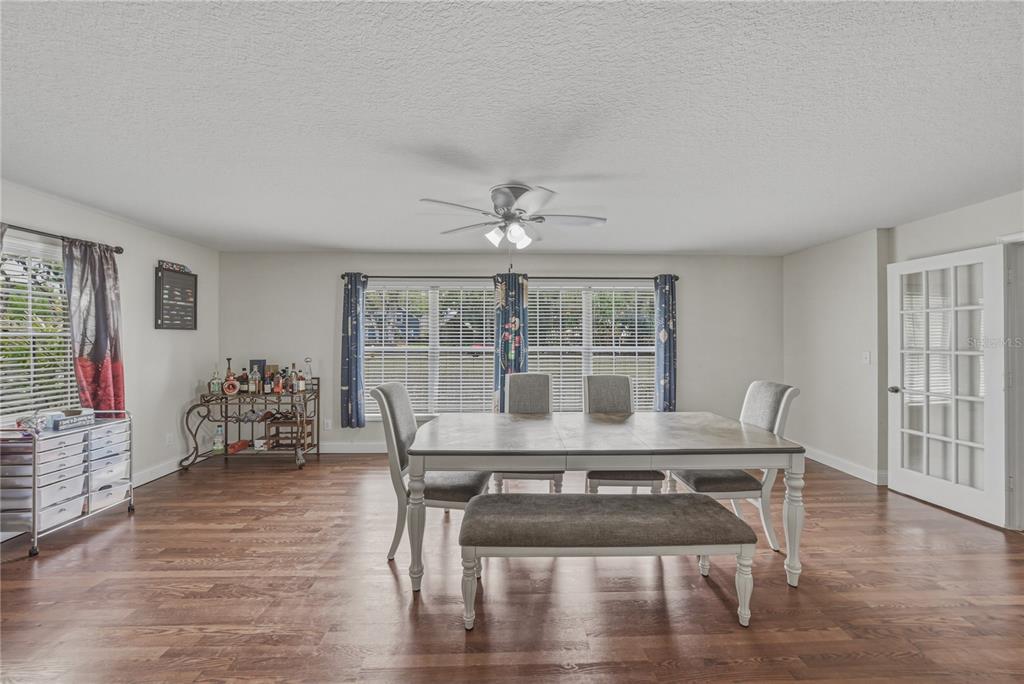 A dining room features a wooden table with chairs and a bench on wood flooring — 609 W PIPKIN ROAD, LAKELAND, FL
