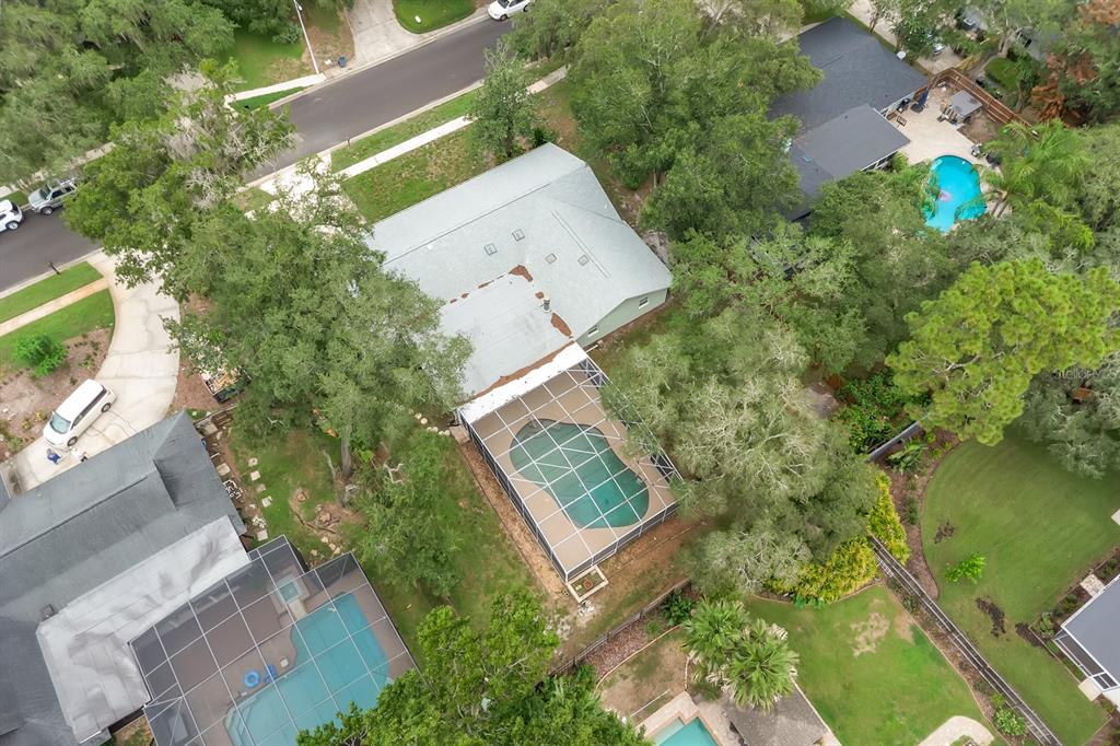 An aerial view shows a house with a screened-in pool and a large backyard — 215 PALMETTO CONCOURSE, LONGWOOD, FL
