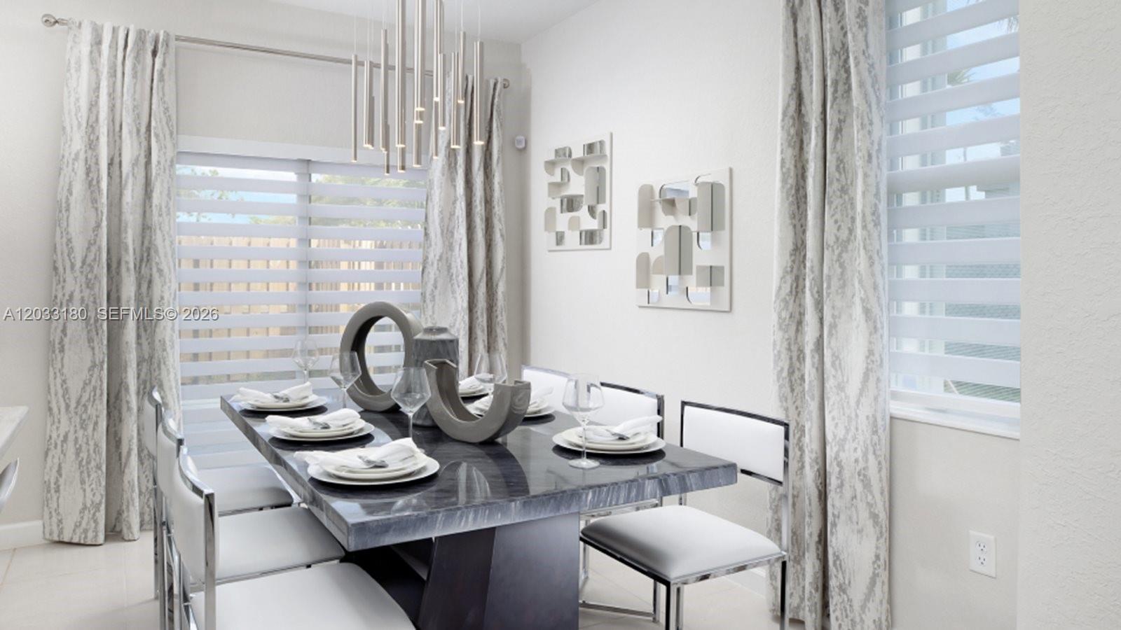 A dining room features a dark marble table, modern chairs, and a contemporary pendant light — 2592 SE 25 RD, Homestead FL 33035, HOMESTEAD, FL