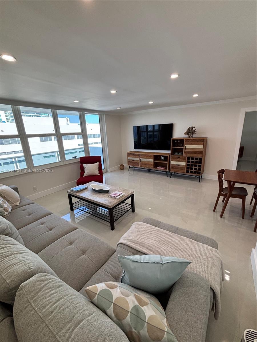 A living room features a gray sectional sofa, stone coffee table, and wood media console — 3725 S Ocean Dr # 1225, Hollywood FL 33019, HOLLYWOOD, FL