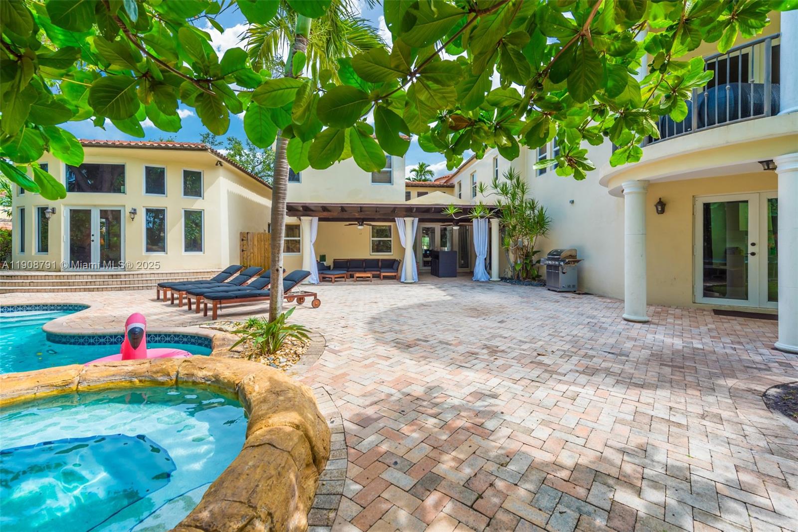 A backyard patio features a pool, hot tub, lounge chairs, and a covered seating area — 1051 NE 89th St, Miami FL 33138, MIAMI, FL