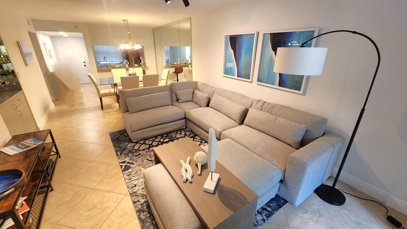 A living room features a large grey sectional sofa, a coffee table, and area rug — 600 Egret Circle # 7103, Delray Beach FL 33444, DELRAY BEACH, FL