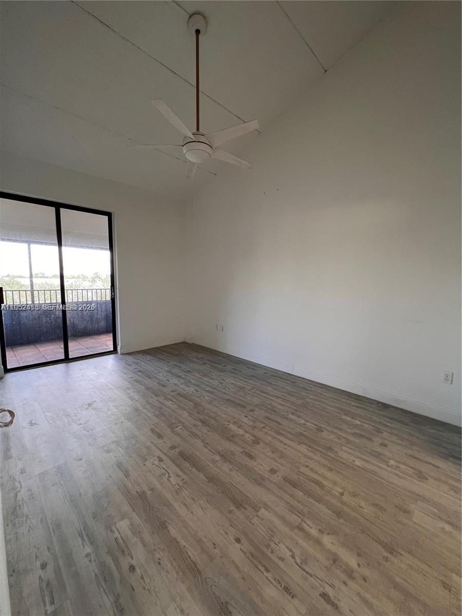 A room with light wood-look flooring, white walls, a ceiling fan, and a sliding glass door — 16220 NW 2nd Ave # 511, Miami FL 33169, MIAMI, FL