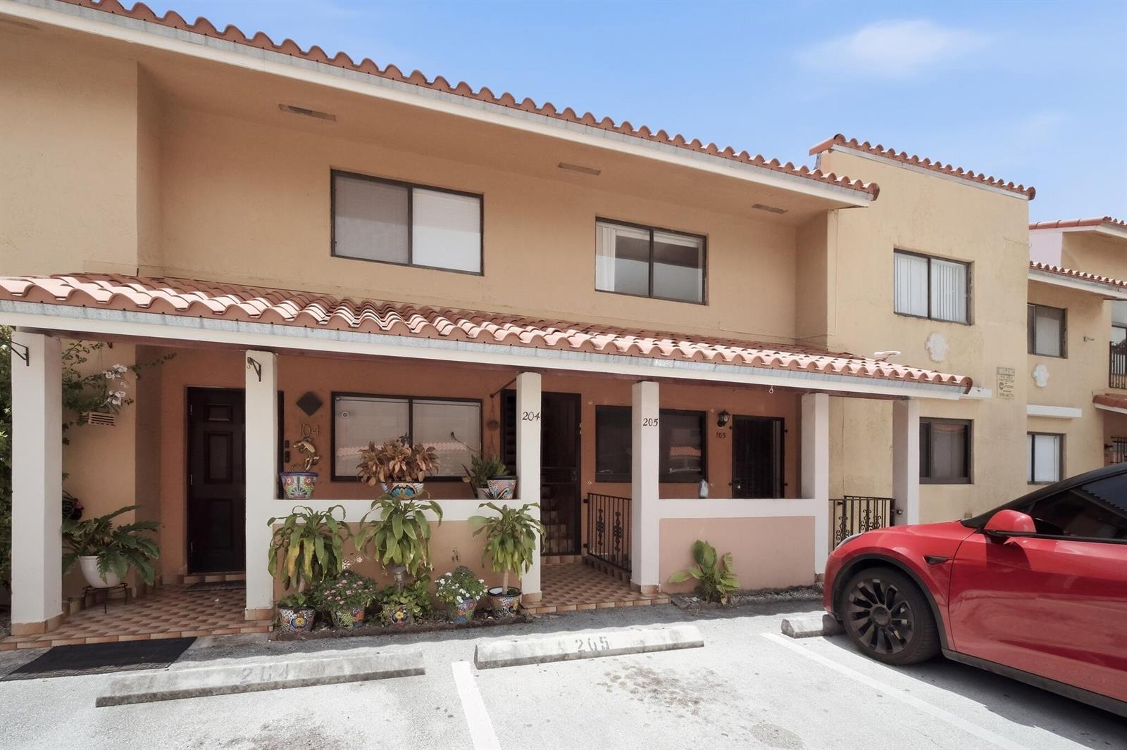 A two-story tan apartment building with a tiled roof and a covered front porch — 2710 W 60th Place # 205, Hialeah FL 33016, HIALEAH, FL