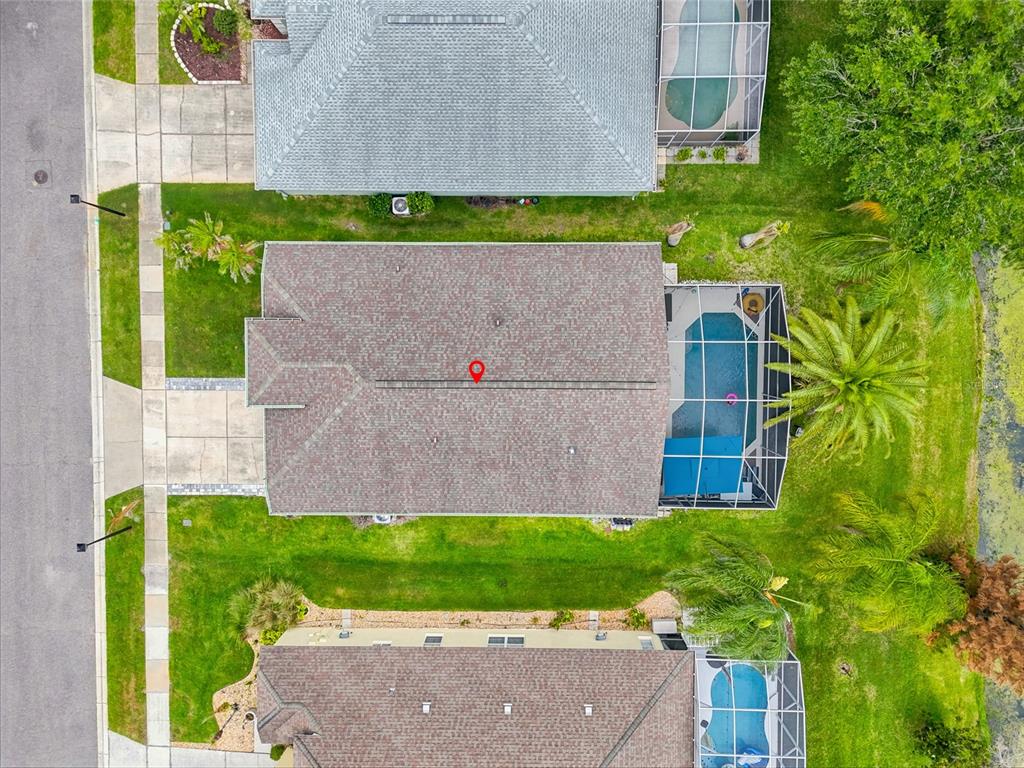 An aerial view shows a residential house with a pool enclosure and a backyard pond — 2613 RUNYON CIRCLE, ORLANDO, FL