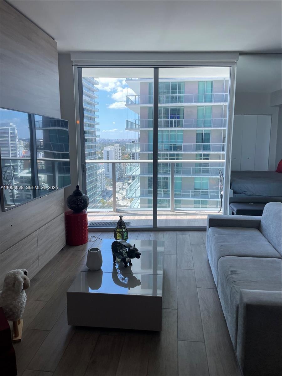 A living room features a grey sofa, a coffee table, and a balcony with city views — 1100 S Miami Ave # 2105, Miami FL 33130, MIAMI, FL