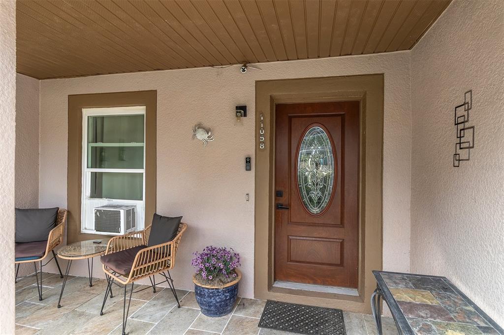 A covered front porch features a wooden door with a decorative glass oval insert — 11058 N MORRELL DRIVE, CITRUS SPRINGS, FL