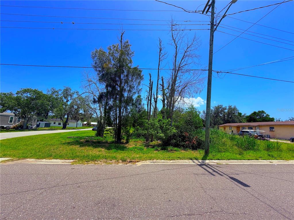 A vacant, grassy lot with several trees sits between two residential buildings — 925 GRAND AVENUE, SEBRING, FL