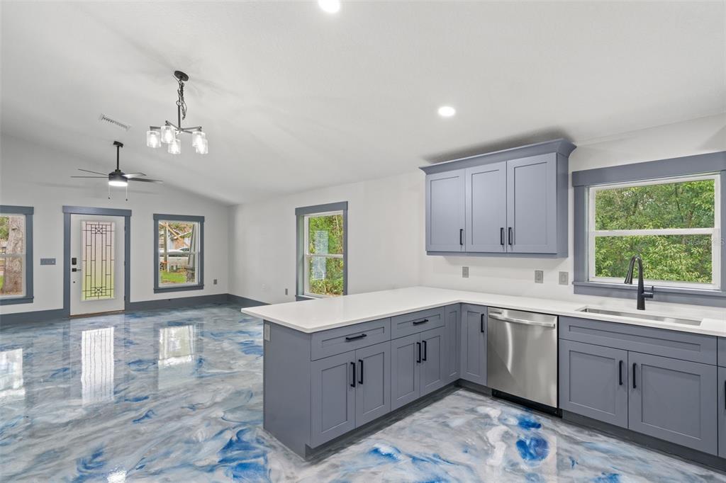 A kitchen with blue cabinets and a white countertop features a blue-and-white marbled epoxy floor — 478 LINCOLN AVENUE, BROOKSVILLE, FL