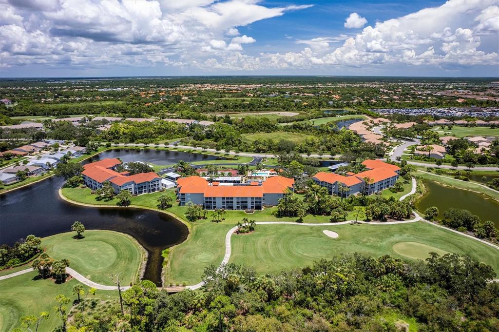 A sunroom with a glass dining table overlooks a lake and a golf course — 9320 CLUBSIDE CIRCLE UNIT 2108, SARASOTA, FL