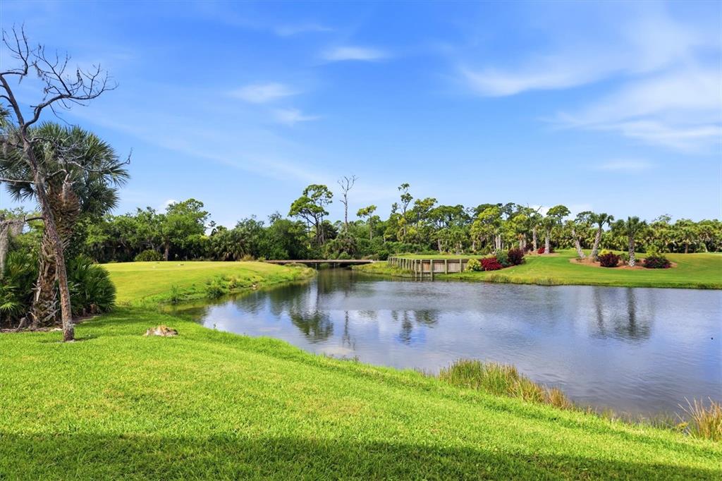 An aerial view shows apartment buildings with orange roofs surrounded by ponds and golf courses — 9320 CLUBSIDE CIRCLE UNIT 2108, SARASOTA, FL
