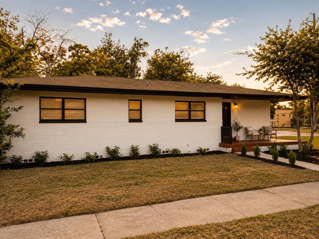 A single-story white brick house with a dark roof and black window frames — 2605 E 17TH AVENUE, TAMPA, FL