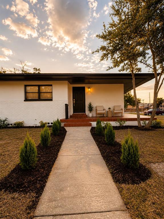 A single-story white brick house with a flat roof and a concrete walkway — 2605 E 17TH AVENUE, TAMPA, FL