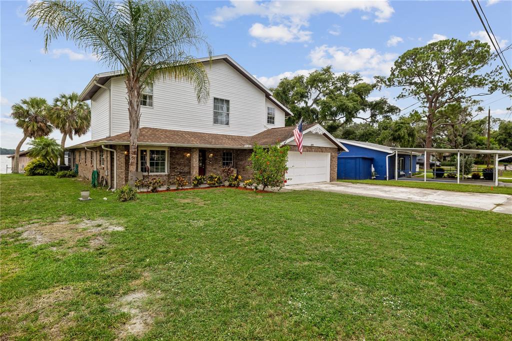 A two-story house with white siding, a brick facade, and an attached garage — 285 LAKEVIEW DRIVE, TARPON SPRINGS, FL