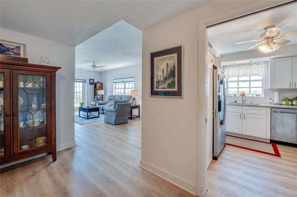 A view from a hallway looking into a living room and an adjacent white kitchen — 404 S BEACH STREET UNIT 230 (604), DAYTONA BEACH, FL