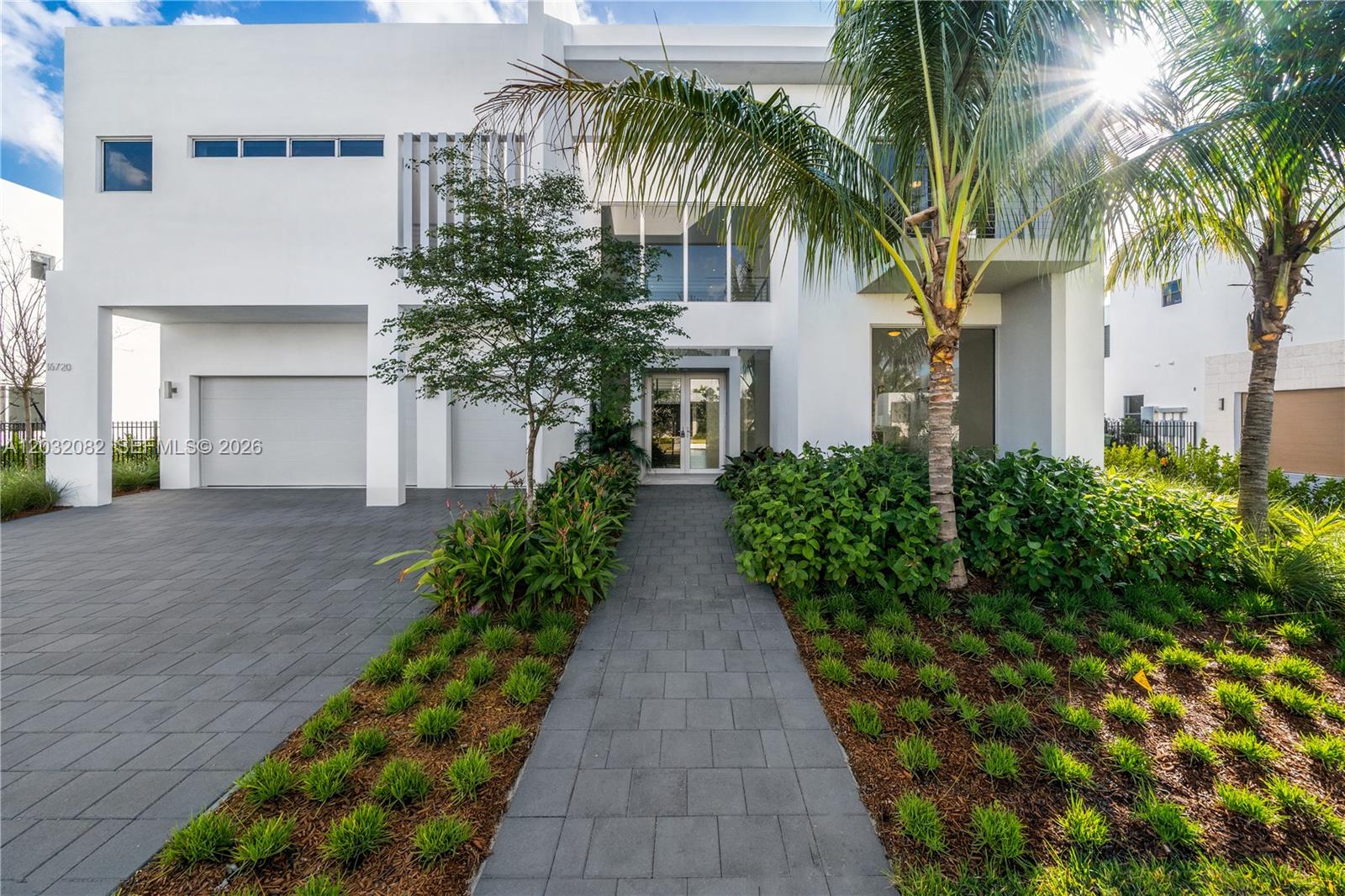 A modern two-story white house features a paved driveway, a walkway, and palm trees — 16720 N Botaniko Dr N, Weston FL 33326, WESTON, FL