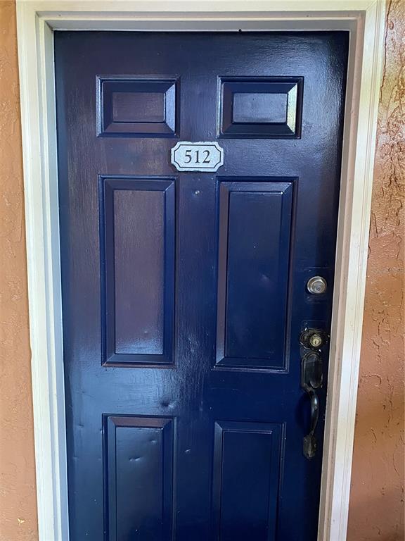 A dark blue front door with the number 512 mounted on the center panel — 5120 CONROY ROAD UNIT 12, ORLANDO, FL