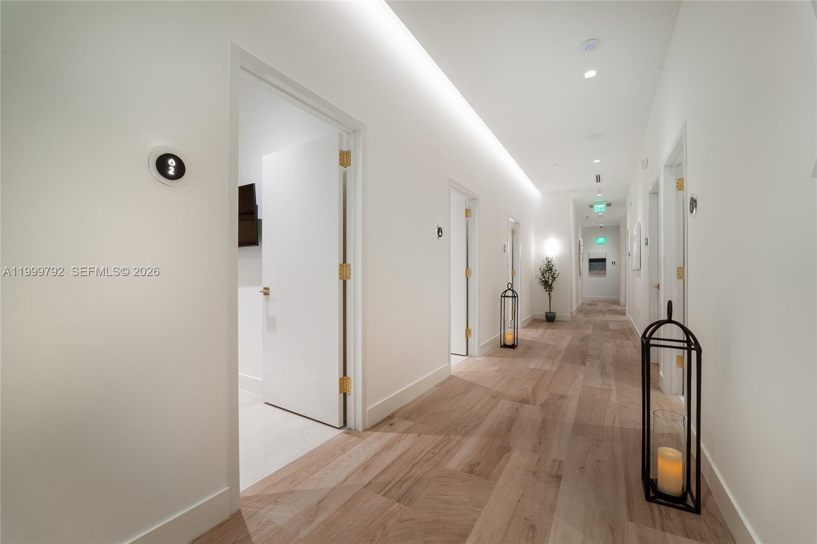 A bright hallway features white walls, light wood flooring, and several doorways with black lanterns — 1340 S Dixie Hwy, Coral Gables FL 33146, CORAL GABLES, FL