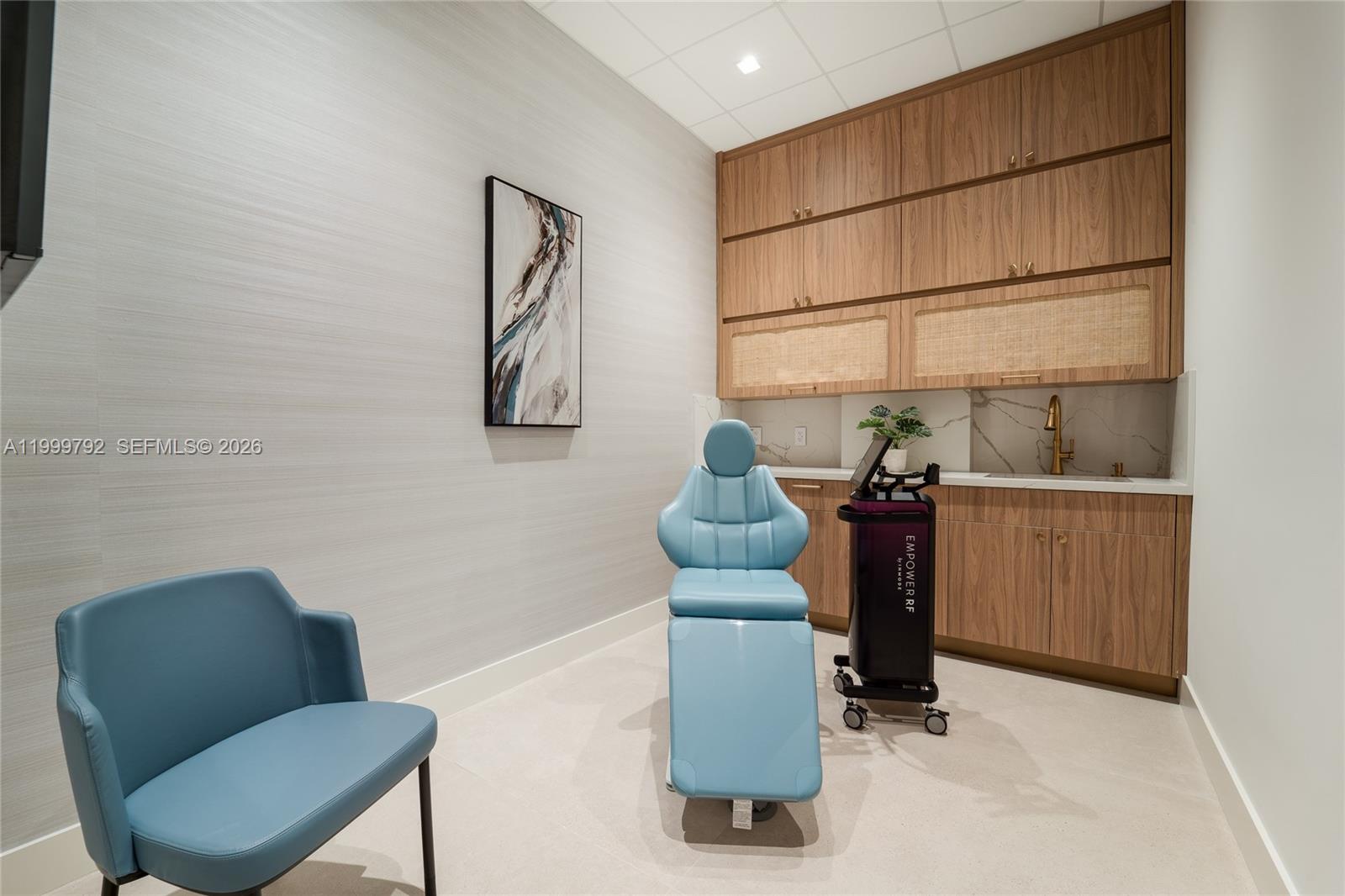 A medical treatment room features a blue procedure chair, cabinetry, and a sink — 1340 S Dixie Hwy, Coral Gables FL 33146, CORAL GABLES, FL