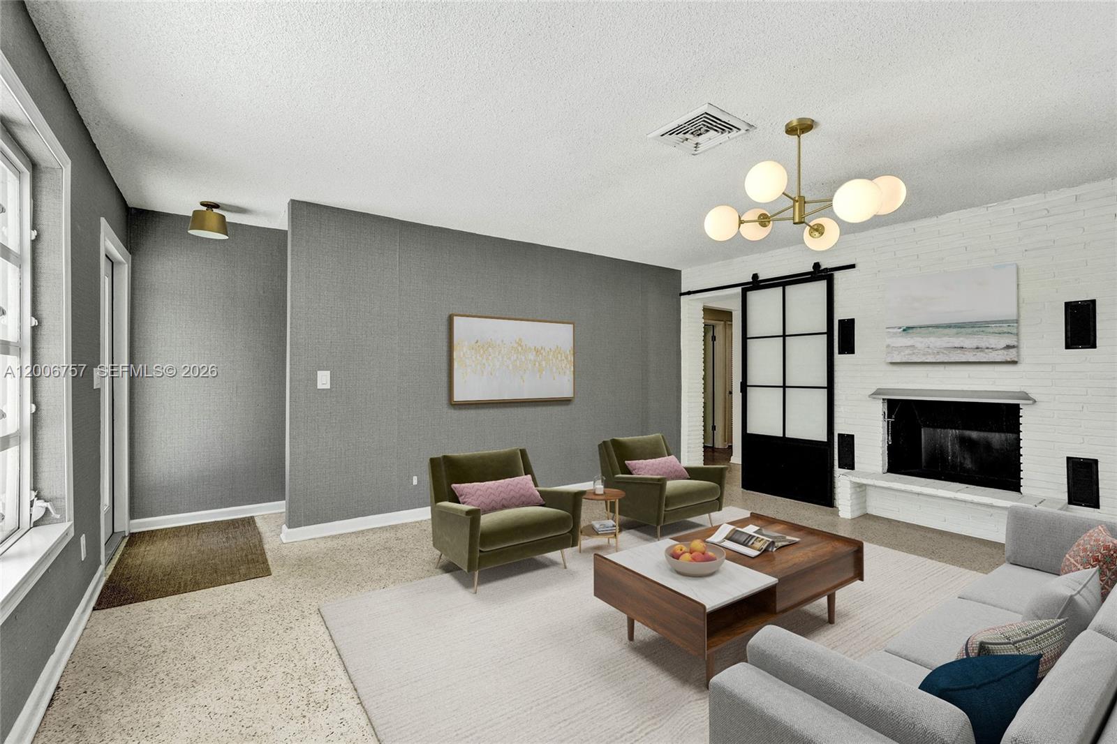 A living room features a white brick fireplace, gray textured walls, and a modern chandelier — 1421 S Palmway, Lake Worth FL 33460, LAKE WORTH, FL
