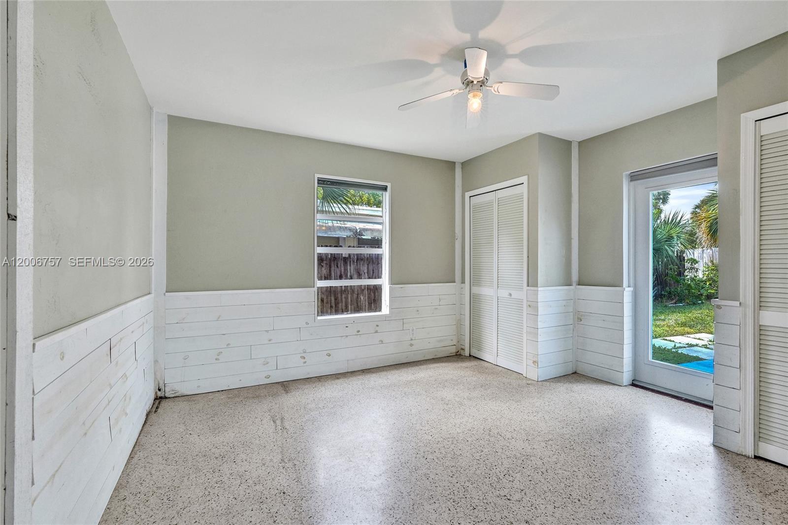 A room with white shiplap wainscoting, a ceiling fan, a closet, and a glass door — 1421 S Palmway, Lake Worth FL 33460, LAKE WORTH, FL