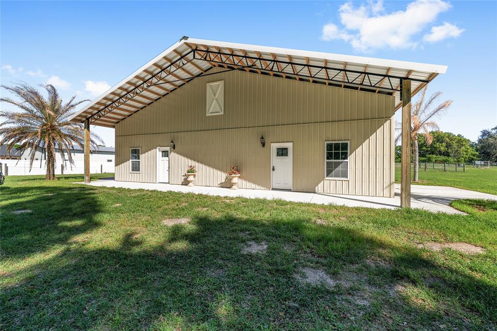 A tan metal building with a covered porch, two white doors, and two windows — 13869 S HWY 475, SUMMERFIELD, FL
