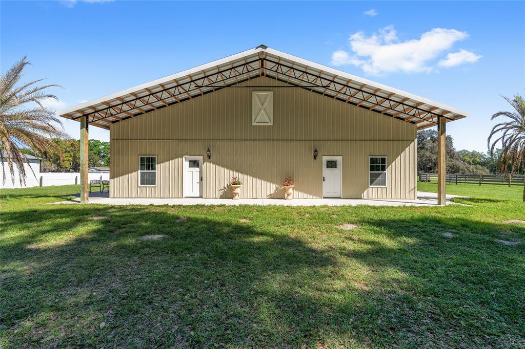 A tan metal building with two white doors and windows sits on a grassy lawn — 13869 S HWY 475, SUMMERFIELD, FL