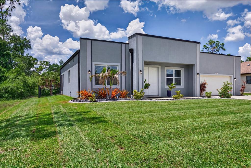A modern gray single-story house with a flat roof and a two-car garage — 2967 JOHANNESBERG ROAD, NORTH PORT, FL
