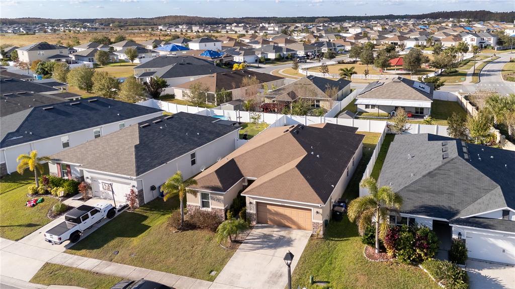 An aerial view shows suburban houses with shingled roofs, driveways, and palm trees — 4563 ORCHARD GROVE ROAD, ST CLOUD, FL