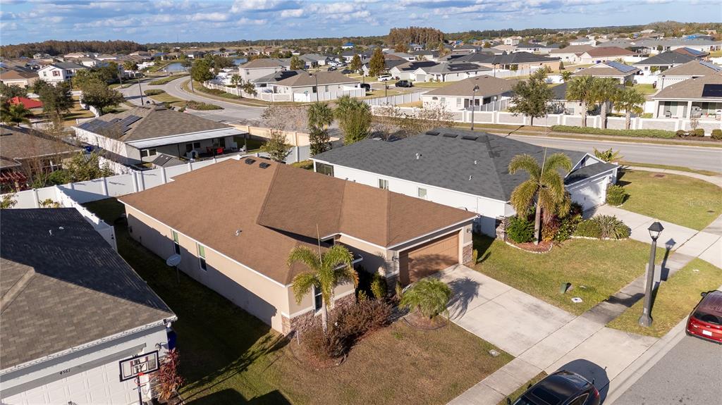 An aerial view shows a suburban neighborhood with single-family homes, driveways, and palm trees — 4563 ORCHARD GROVE ROAD, ST CLOUD, FL