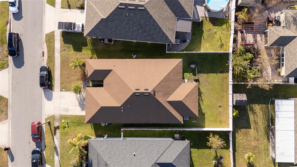 An aerial view shows a suburban house with a brown roof and a fenced backyard — 4563 ORCHARD GROVE ROAD, ST CLOUD, FL