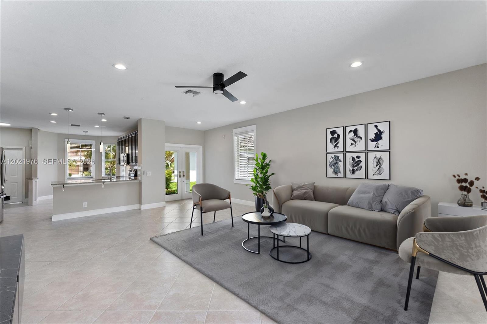 A living room features a gray sofa, two armchairs, a coffee table, and tile flooring — 1868 Silverbell Ter, Weston FL 33327, WESTON, FL