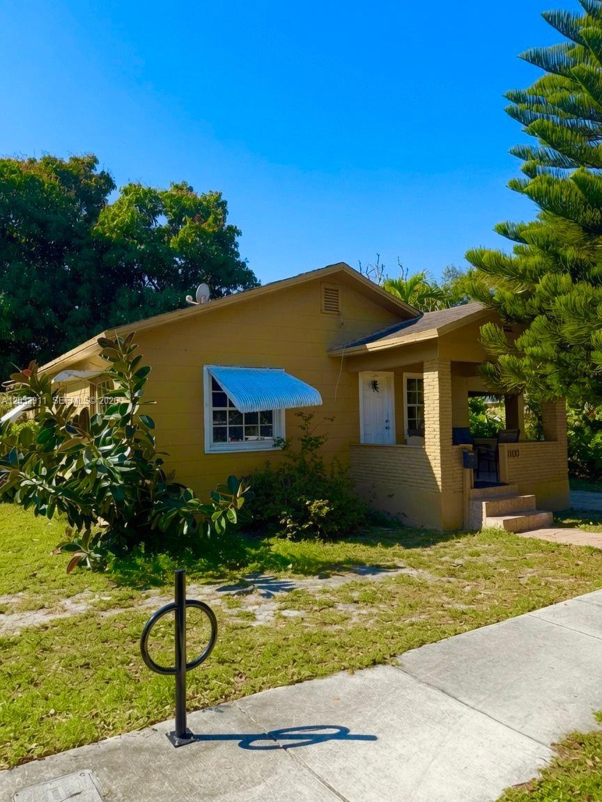 A single-story yellow house with a covered front porch and a blue window awning — 1100 N 24th Ave, Hollywood FL 33020, HOLLYWOOD, FL