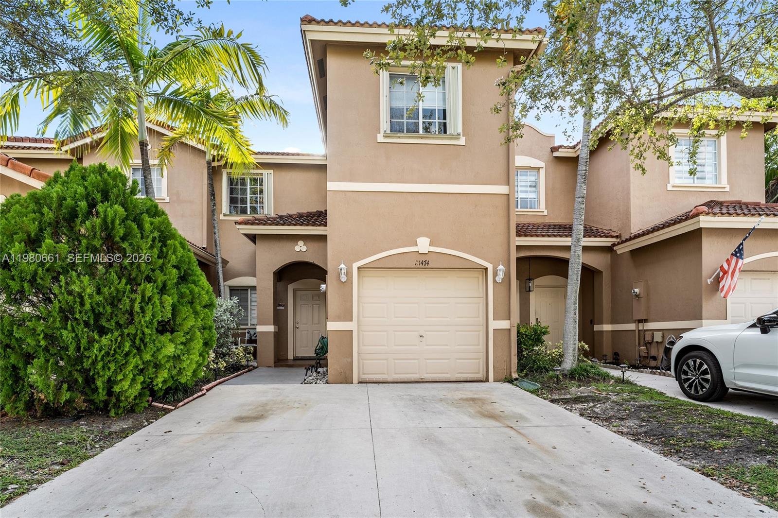 A two-story tan stucco townhouse features a single-car garage and a concrete driveway — 21474 SW 85th Path, Cutler Bay FL 33189, CUTLER BAY, FL