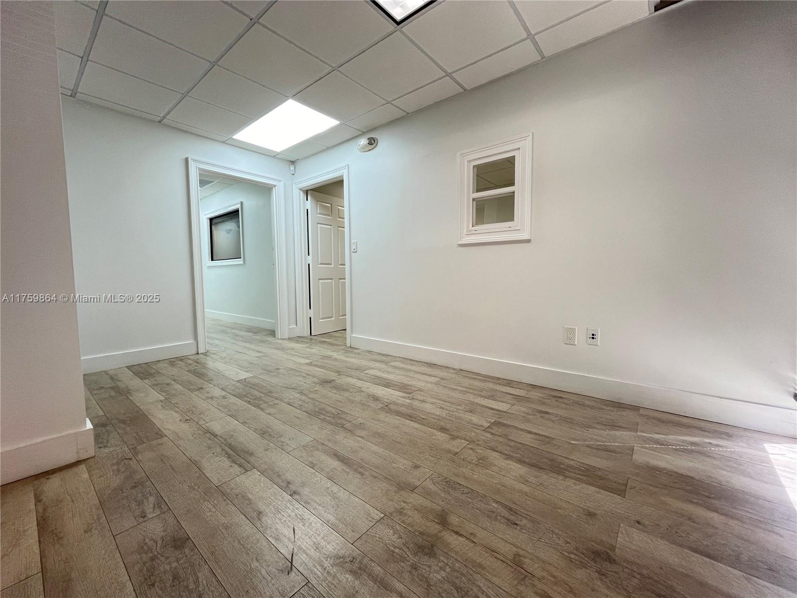 An office room features white walls, a drop ceiling, and light-colored wood-look flooring — 4350 NW 19th Ave # C, Deerfield Beach FL 33064, DEERFIELD BEACH, FL