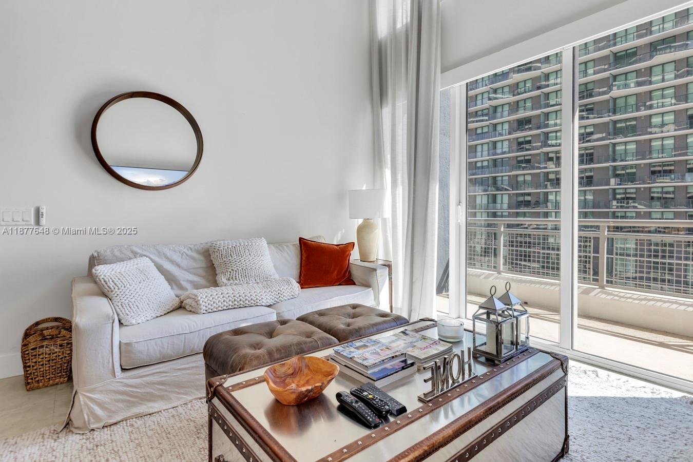 A living room features a white sofa, leather ottomans, and a metal trunk coffee table — 60 SW 13th St # 3402, Miami FL 33130, MIAMI, FL