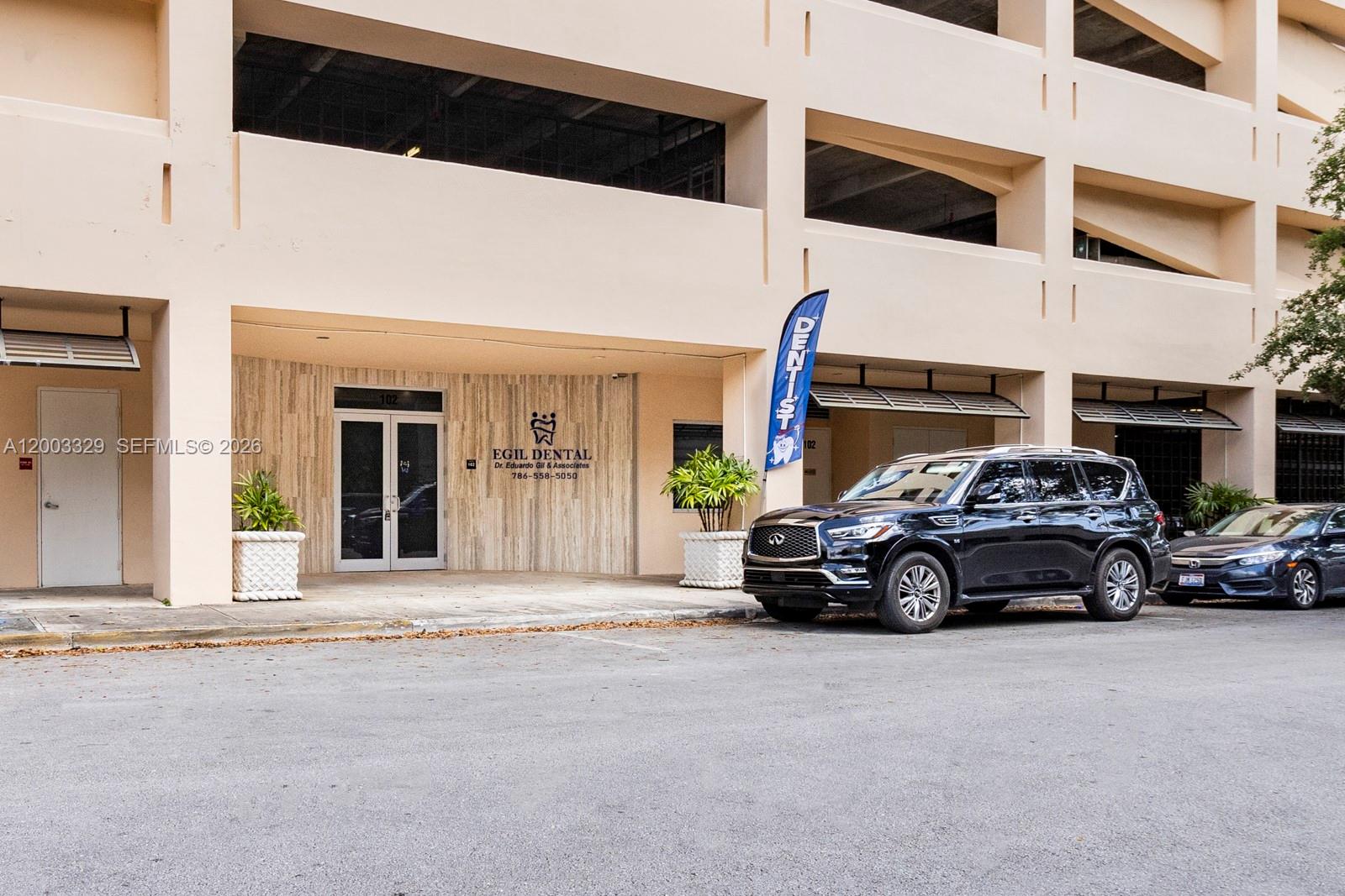 The exterior of a commercial building features a dental office entrance with a parked SUV — 6141 Sunset Dr # 102, South Miami FL 33143, SOUTH MIAMI, FL