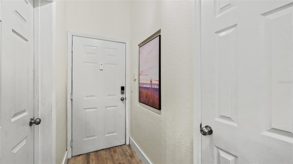 A white front door sits between two interior doors in a hallway with light flooring — 13810 SUTTON PARK DRIVE N UNIT 1336, JACKSONVILLE, FL