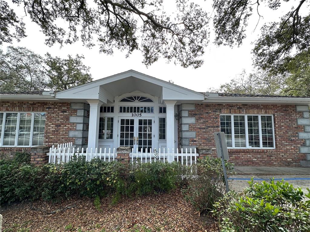 A single-story brick building features a white-pillared entrance with double glass doors and windows — 1005 PINELLAS STREET, CLEARWATER, FL