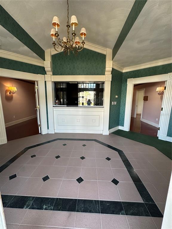 A foyer features a chandelier, green patterned wallpaper, and a tiled floor with dark accents — 1005 PINELLAS STREET, CLEARWATER, FL