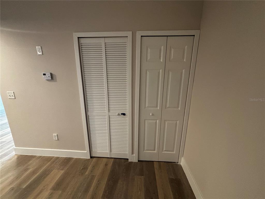 A room features wood-look flooring, beige walls, and two adjacent white closet doors — 4424 S TEXAS AVENUE UNIT 314, ORLANDO, FL