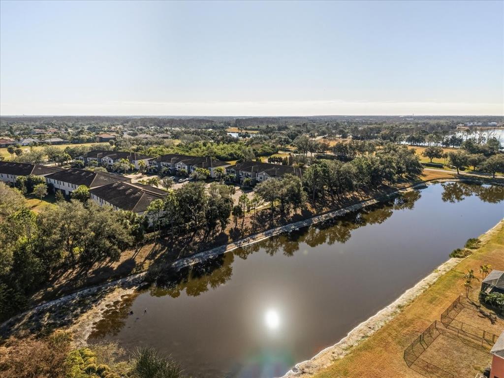 An aerial view shows a multi-family residential complex situated next to a large pond — 7224 KETCH PLACE, BRADENTON, FL