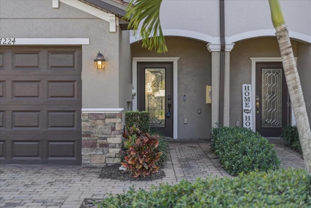 The exterior of a home features a garage, stone accents, and two front entry doors — 7224 KETCH PLACE, BRADENTON, FL