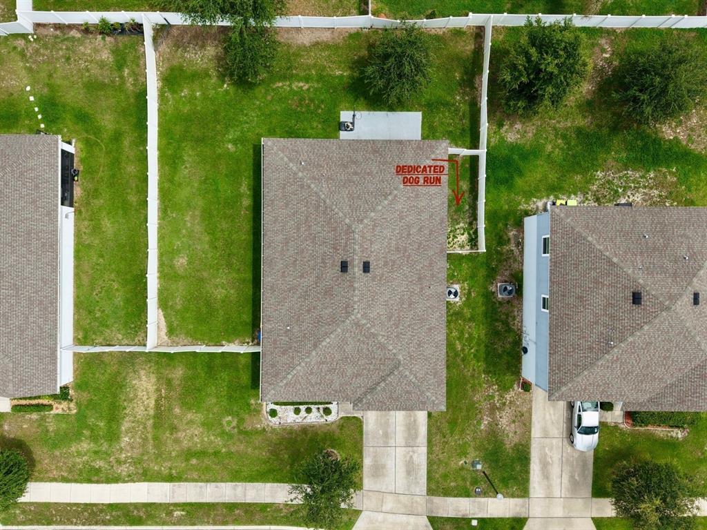 An aerial view shows a residential house with a fenced backyard and a dedicated dog run — 15280 WHITE TAIL LOOP, MASCOTTE, FL